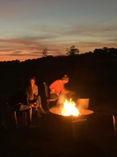Participants catching up around the firepit as the sun sets.